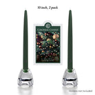 Two green candles in holders with a Colonial Candle packaging in the background on a white background.