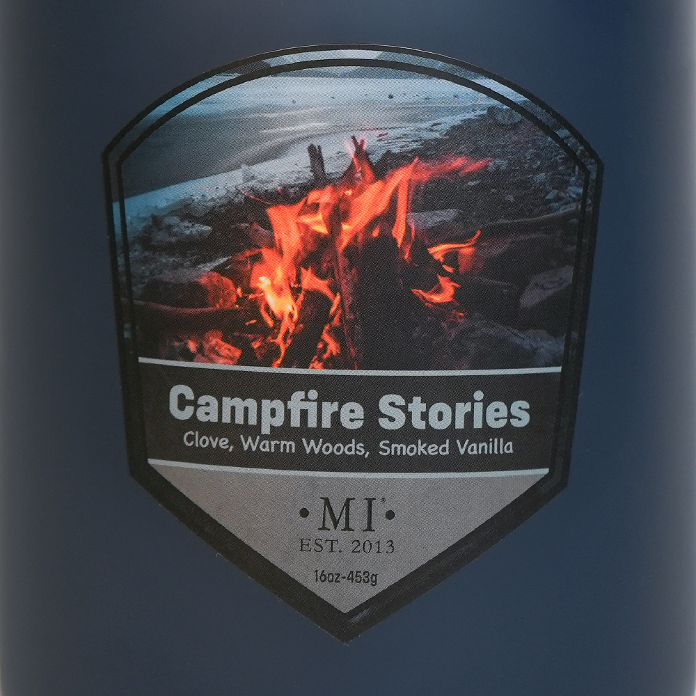 Label of 'Campfire Stories' candle featuring a campfire design on a blue background