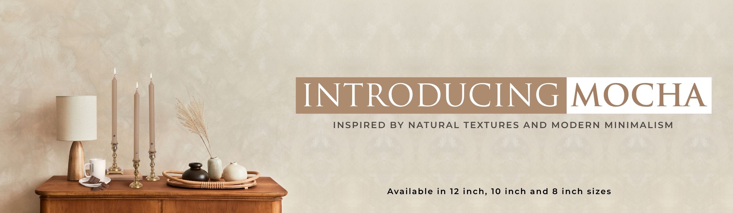 Decorative setting with candles and a wooden table against a beige wall, introducing 'Mocha' collection.