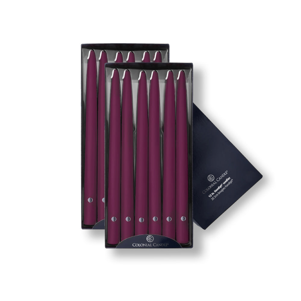 A set of mulberry colored taper candles, 12 inches in length, presented in a packaging that indicates they are handipt, with a burn time of up to 10 hours.