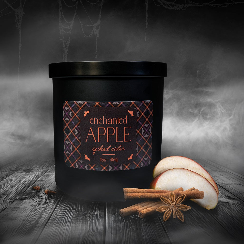 Black container labeled 'Enchanted Apple' with sliced apples and cinnamon sticks on a dark background