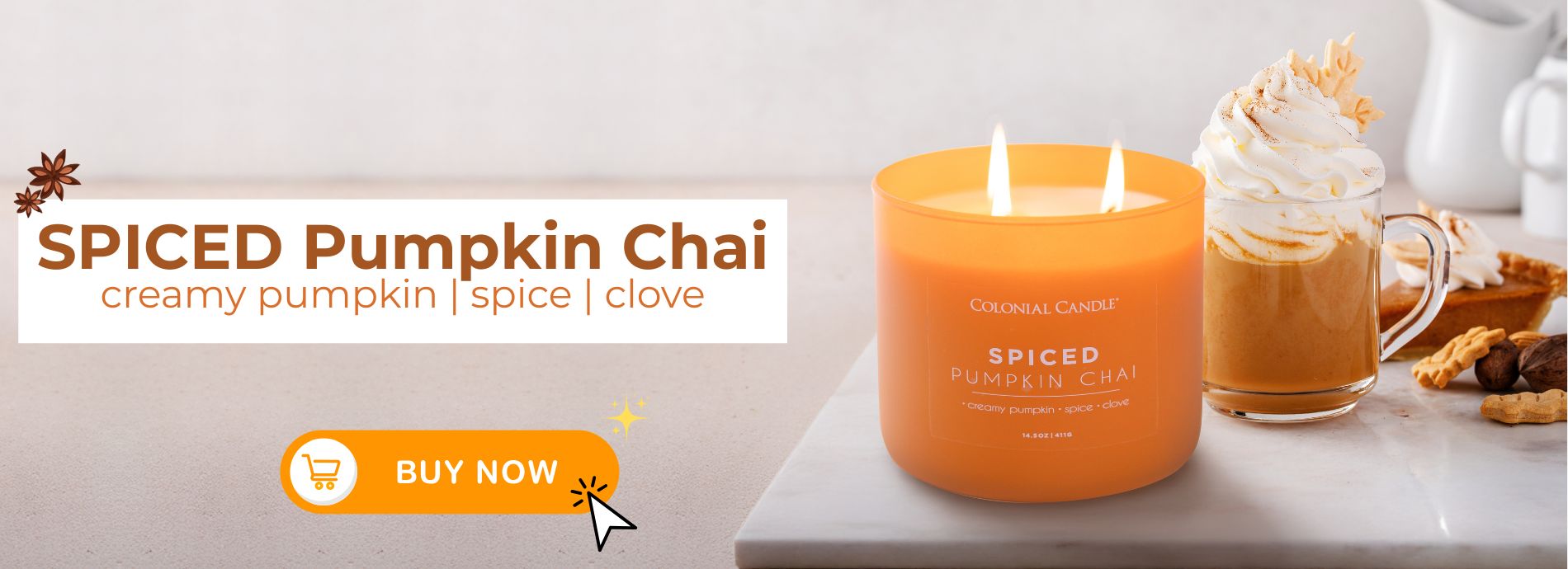 Spiced Pumpkin Chai candle with a glass of pumpkin spice latte on a white surface.
